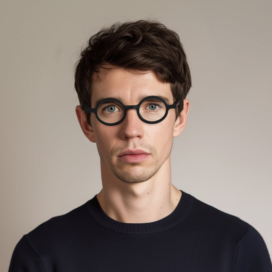 Male model - Moley Blue Blocker Glasses in matt black featuring an eccentrically round frame and the ability to protect your eyes from artificial blue light. Ideal for fashion accessories, screen time, office work, gaming, scrolling on a mobile, and watching TV. 