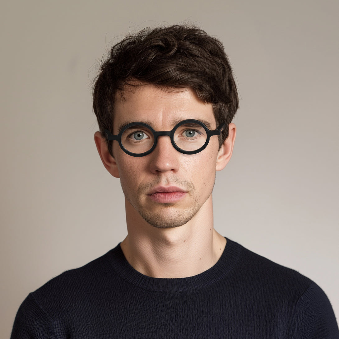 Male model - Moley Reading Glasses in matt black featuring an eccentrically round frame and provide crystal clear vision. Available in a + 1, 1.5, 2, 2.5, 3 prescriptions.