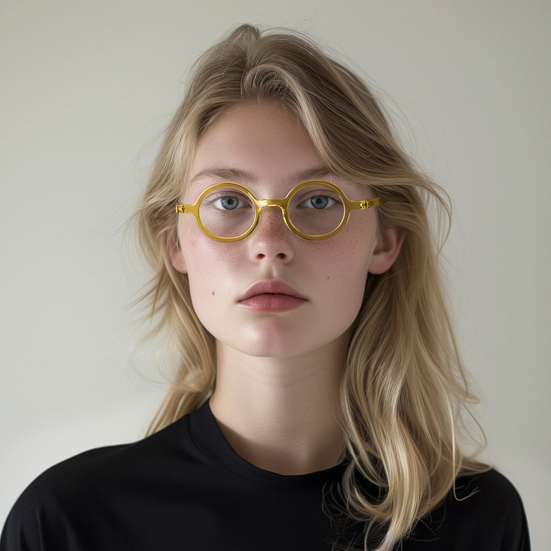 Female model - Moley Blue Blocker Glasses in transparent yellow featuring an eccentrically round frame and the ability to protect your eyes from artificial blue light. Ideal for fashion accessories, screen time, office work, gaming, scrolling on a mobile, and watching TV. 