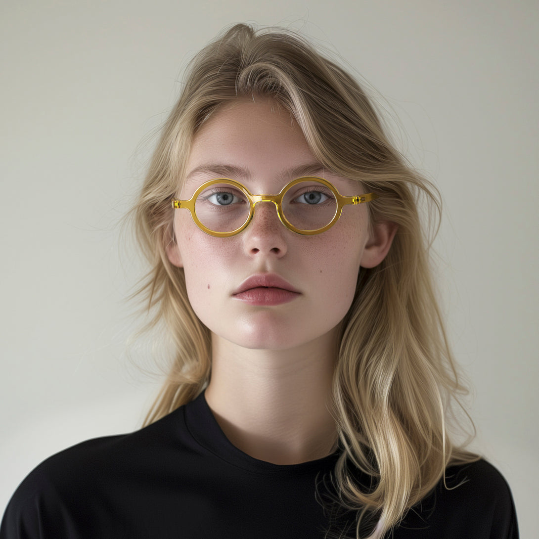 Female model - Moley Reading Glasses in transparent yellow featuring an eccentrically round frame and provide crystal clear vision. Available in a + 1, 1.5, 2, 2.5, 3 prescriptions.