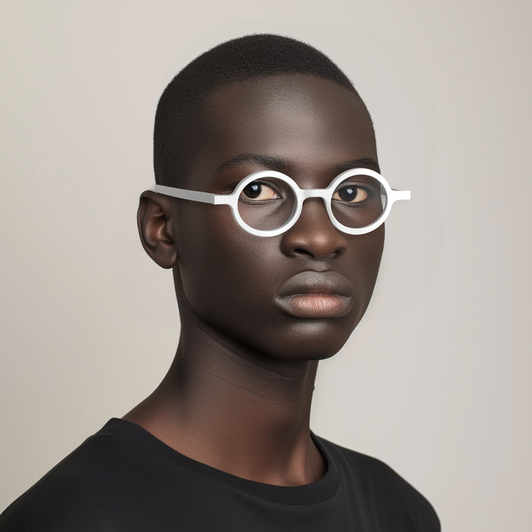 Male model - Moley Reading Glasses in matt white featuring an eccentrically round frame and provide crystal clear vision. Available in a + 1, 1.5, 2, 2.5, 3 prescriptions.