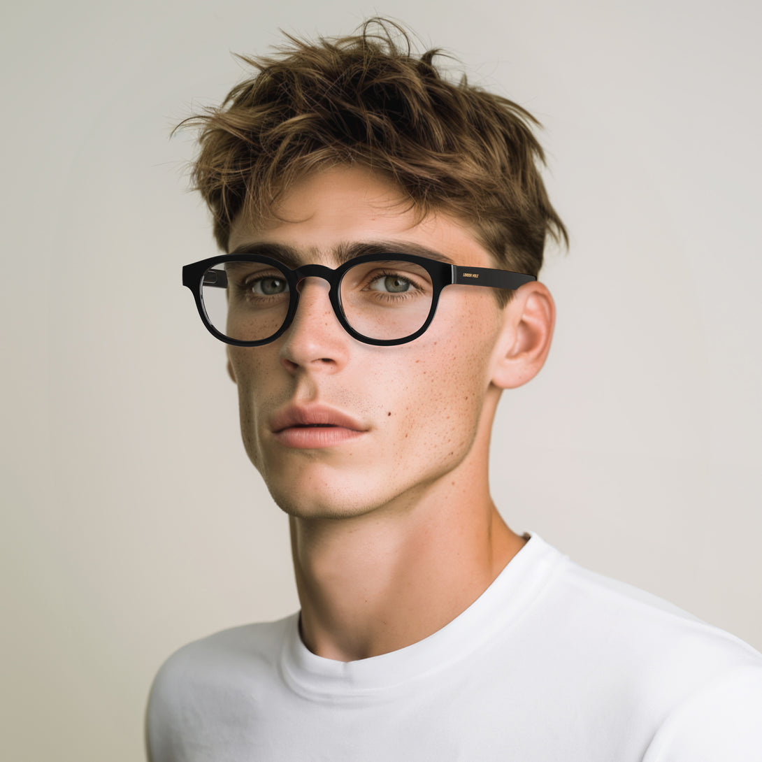 Male model - Monalux Blue Blocker Glasses in gloss black featuring a the classic Oxford, rounded frame and the ability to protect your eyes from artificial blue light. Ideal for fashion accessories, screen time, office work, gaming, scrolling on a mobile, and watching TV. 