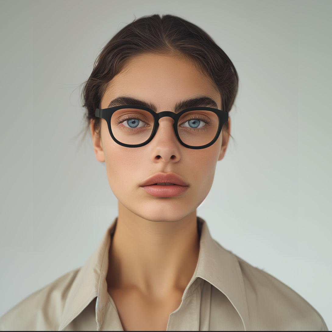 Female model - Monalux Blue Blocker Glasses in matt black featuring a the classic Oxford, rounded frame and the ability to protect your eyes from artificial blue light. Ideal for fashion accessories, screen time, office work, gaming, scrolling on a mobile, and watching TV. 
