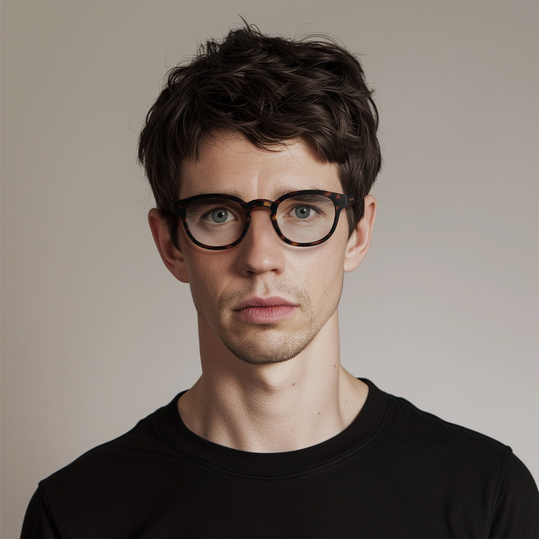 Male model - Monalux Blue Blocker Glasses in matt tortoiseshell featuring a the classic Oxford, rounded frame and the ability to protect your eyes from artificial blue light. Ideal for fashion accessories, screen time, office work, gaming, scrolling on a mobile, and watching TV. 