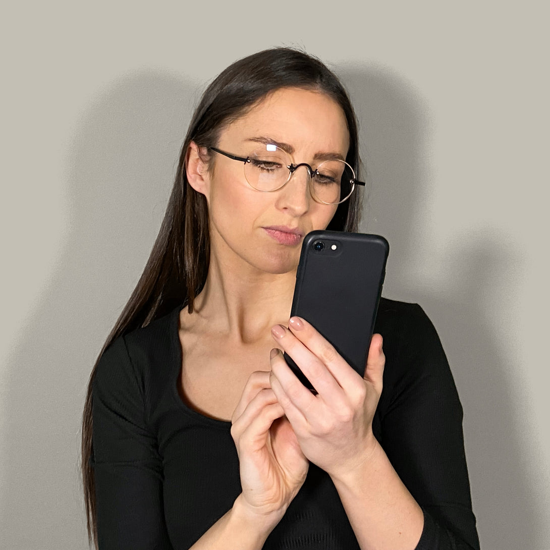 Female model - Scientist Blue Blocker Glasses in matt black offering a frameless lens and matt black temples. With the ability to protect your eyes from artificial blue light they are ideal for fashion accessories, screen time, office work, gaming, scrolling on a mobile, and watching TV. 
