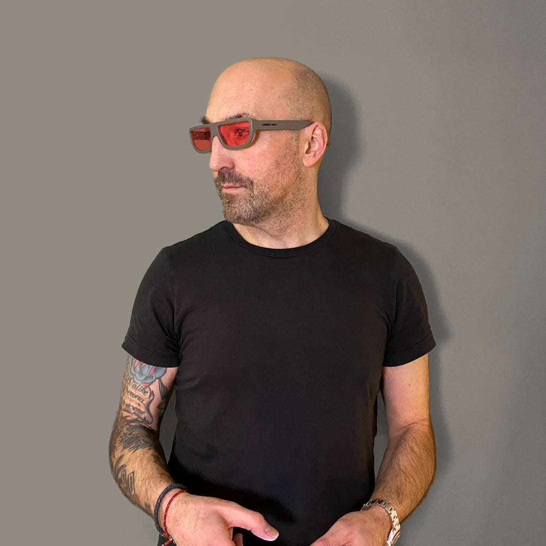 Male model - Feisty sunglasses in matt grey featuring a utilitarian, straight top line frame and red UV400 lenses. The finishing touch to every outfit while protecting your eyes. 