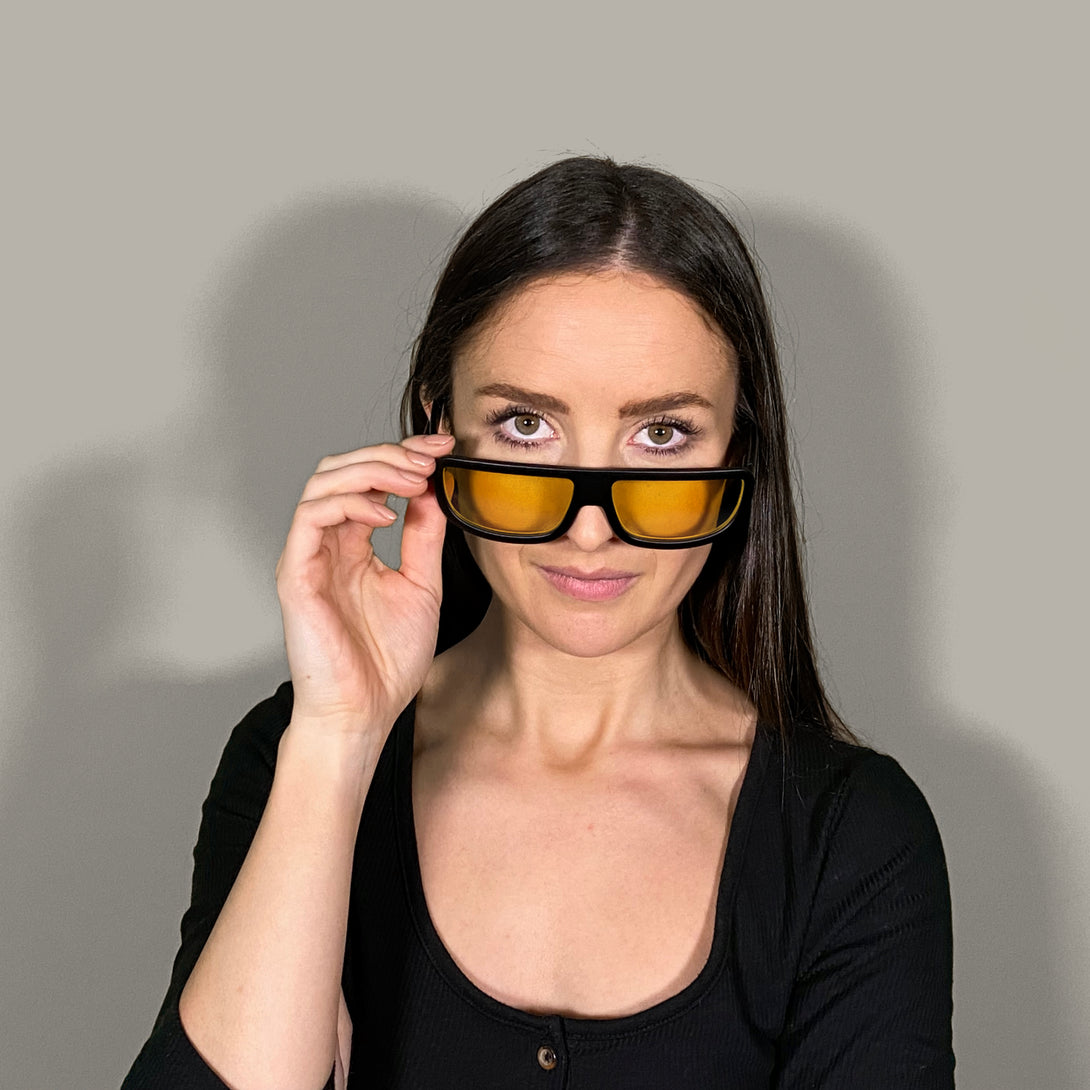 Female model - Feisty sunglasses in matt black featuring a utilitarian, straight top line frame and yellow UV400 lenses. The finishing touch to every outfit while protecting your eyes. 
