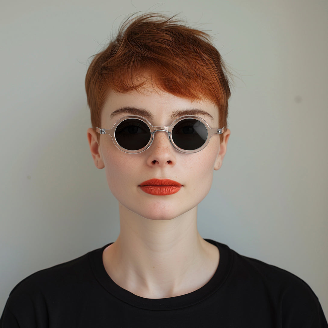 Female model - Moly sunglasses featuring an eccentrically round, transparent frame and black UV400 lenses. The perfect accessory.