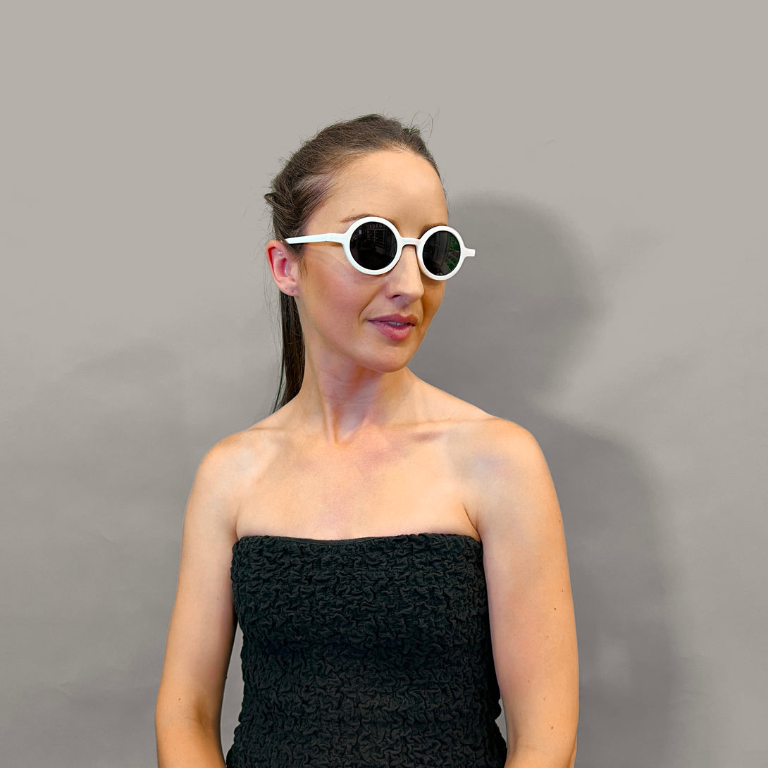 Female model 2 - Moly sunglasses in matt white featuring an eccentrically round frame and black UV400 lenses. The perfect accessory.