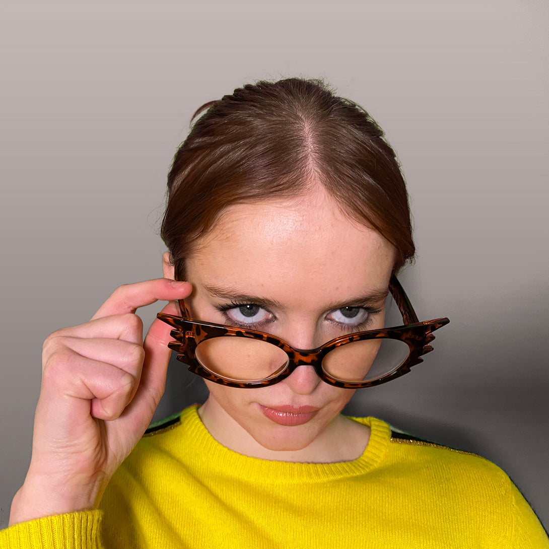 Female model - Speedy Blue Blocker Glasses in gloss tortoiseshell featuring an extravagent vintage frame with a utilitarian look and the ability to protect your eyes from artificial blue light. Ideal for fashion accessories, screen time, office work, gaming, scrolling on a mobile, and watching TV. 