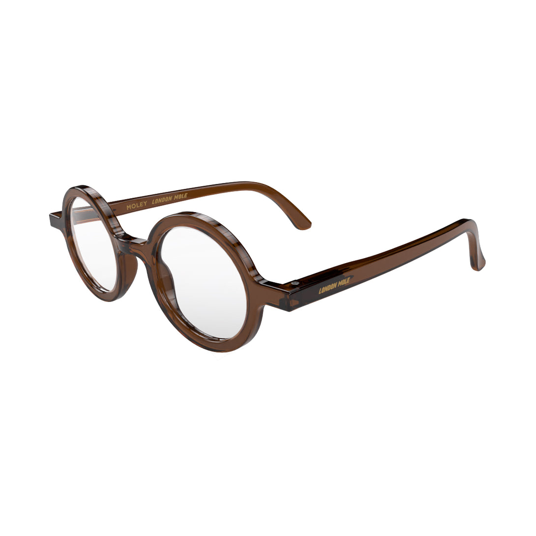 Open skew - Moley Reading Glasses in transparent brown featuring an eccentrically round frame and provide crystal clear vision. Available in a + 1, 1.5, 2, 2.5, 3 prescriptions.