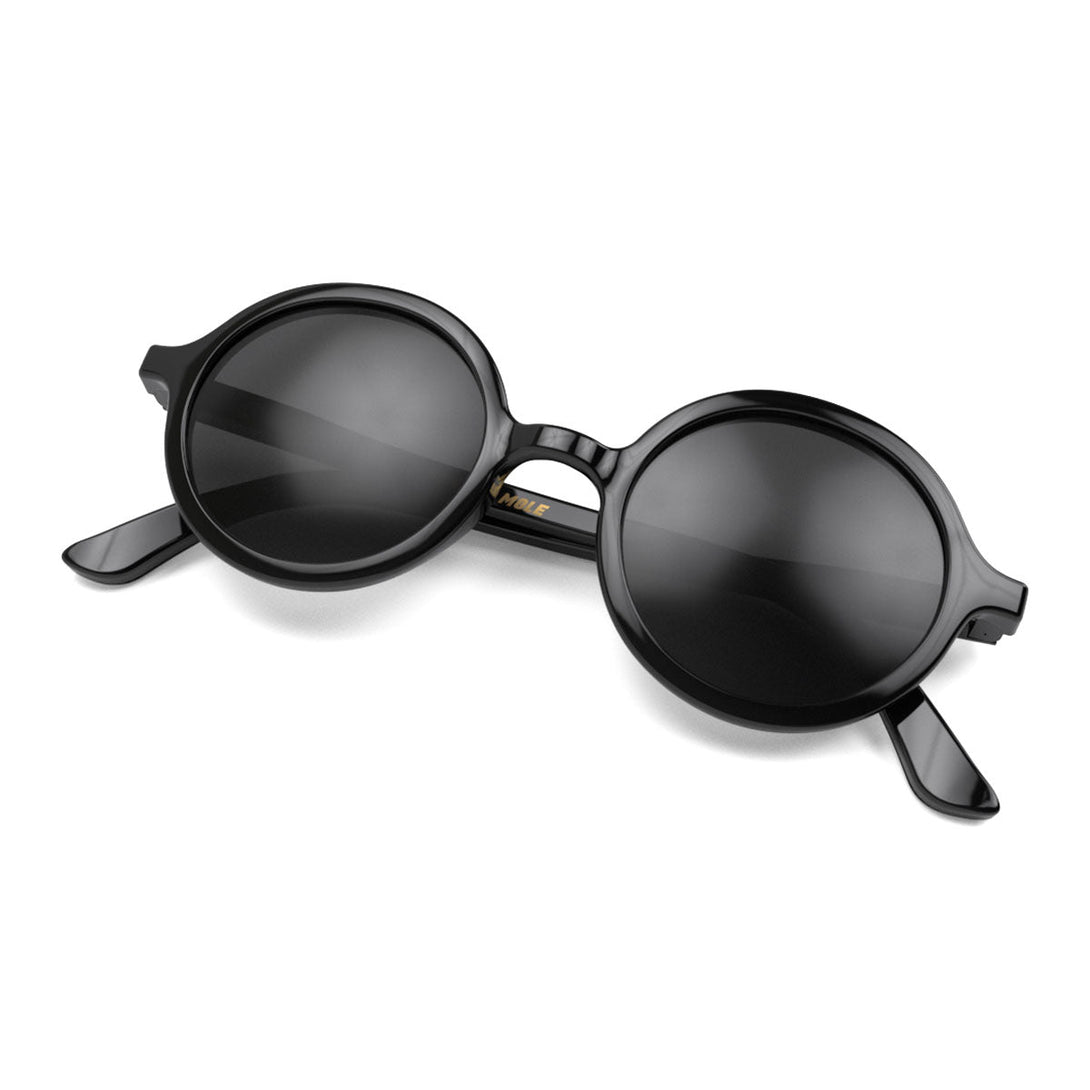 Folded skew - Artist sunglasses in gloss black featuring an oversized circular frame and black UV400 lenses. The finishing touch to every outfit while protecting your eyes. 