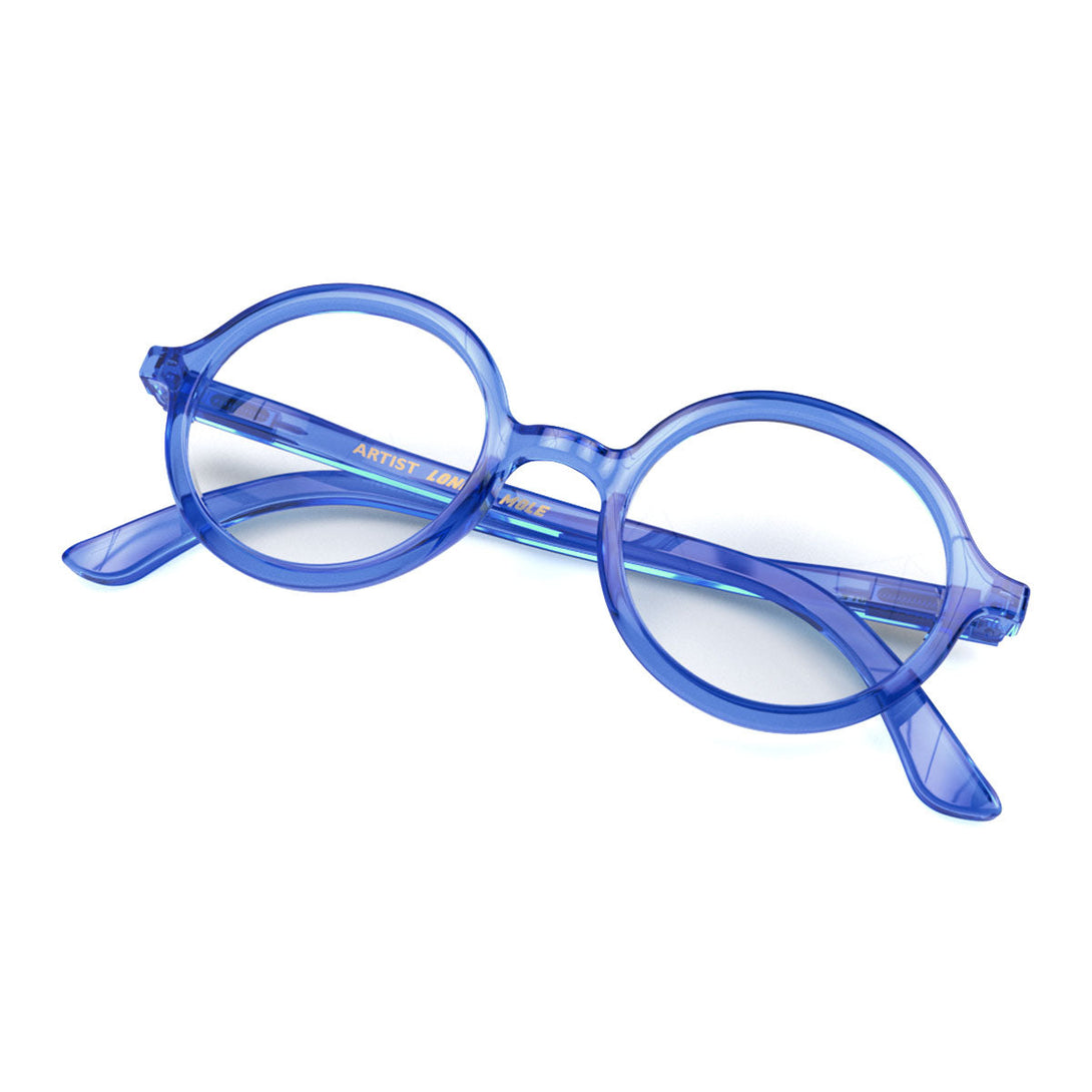 Skew - Artist Reading Glasses in transparent blue featuring an oversized circular frame and provide crystal clear vision. Available in a + 1, 1.5, 2, 2.5, 3 prescriptions.