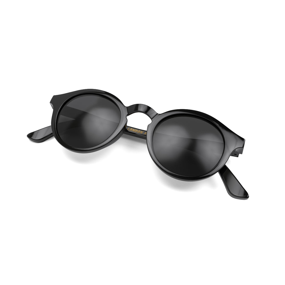 Folded skew - Graduate sunglasses in gloss black featuring a soft circle frame and black UV400 lenses. The finishing touch to every outfit while protecting your eyes. 