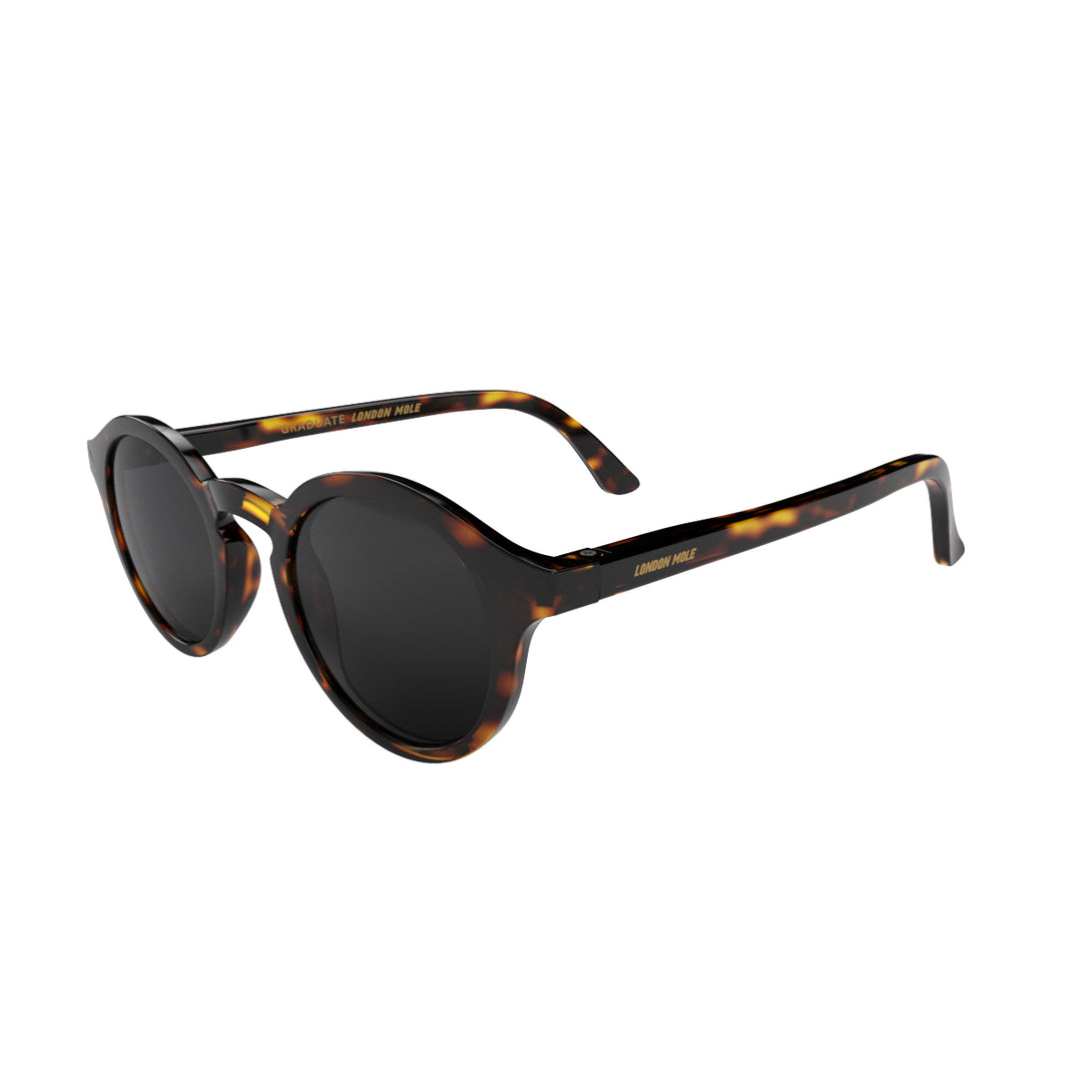 Open skew - Graduate sunglasses in gloss tortoiseshell featuring a soft circle frame and black UV400 lenses. The finishing touch to every outfit while protecting your eyes. 
