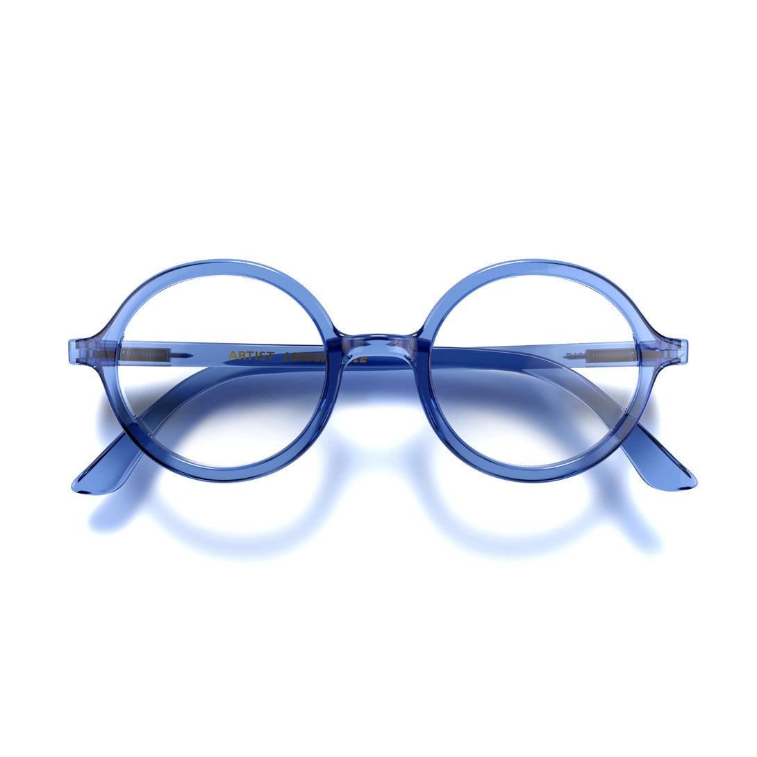 Front - Artist Reading Glasses in transparent blue featuring an oversized circular frame and provide crystal clear vision. Available in a + 1, 1.5, 2, 2.5, 3 prescriptions.