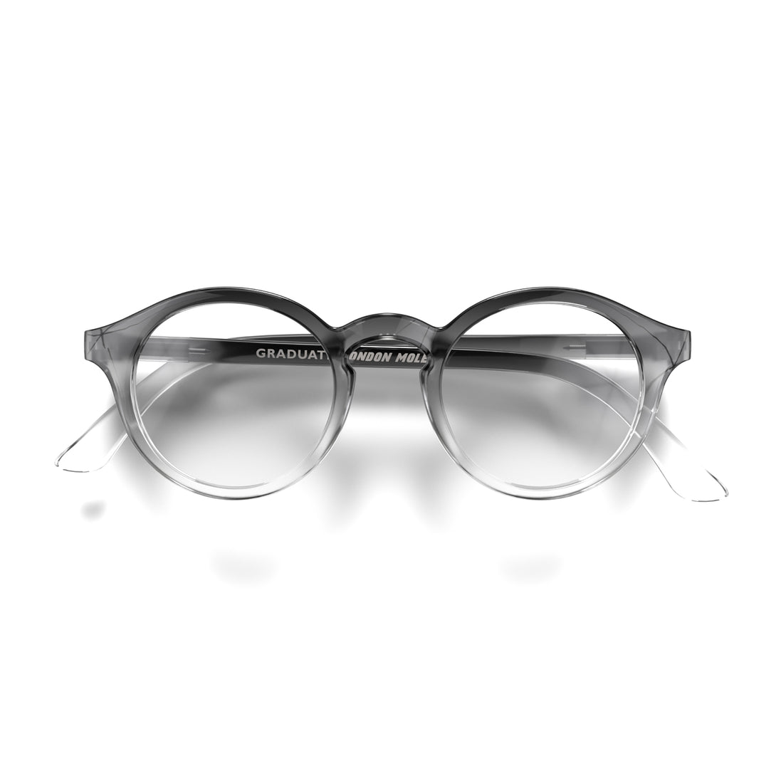 Front - Graduate Reading Glasses in black transparent fade featuring a soft circle frame and provide crystal clear vision. Available in a + 1, 1.5, 2, 2.5, 3 prescriptions.