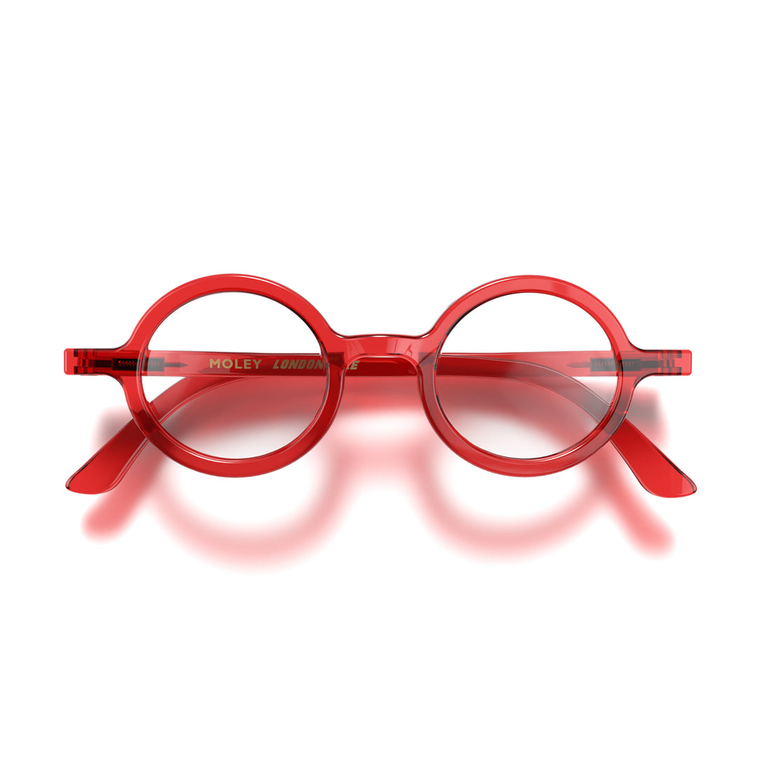 Front - Moley Reading Glasses in transparent red featuring an eccentrically round frame and provide crystal clear vision. Available in a + 1, 1.5, 2, 2.5, 3 prescriptions.
