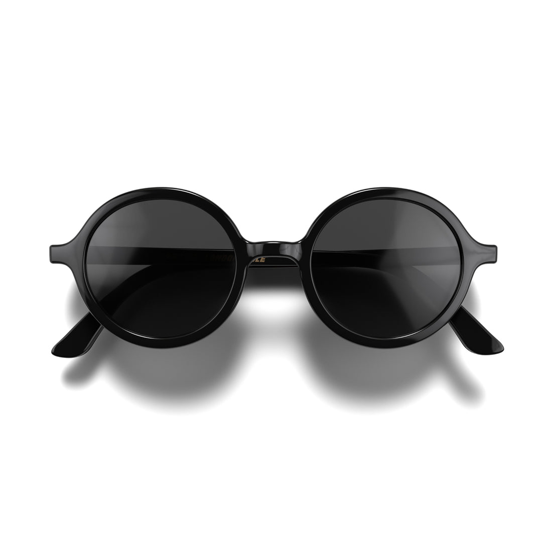 Front - Artist sunglasses in gloss black featuring an oversized circular frame and black UV400 lenses. The finishing touch to every outfit while protecting your eyes. 