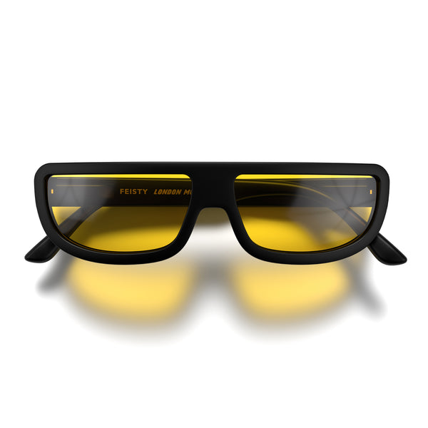 Front - Feisty sunglasses in matt black featuring a utilitarian, straight top line frame and yellow UV400 lenses. The finishing touch to every outfit while protecting your eyes. 