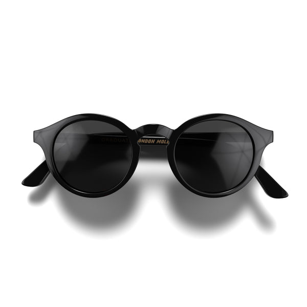 Front - Graduate sunglasses in gloss black featuring a soft circle frame and black UV400 lenses. The finishing touch to every outfit while protecting your eyes. 