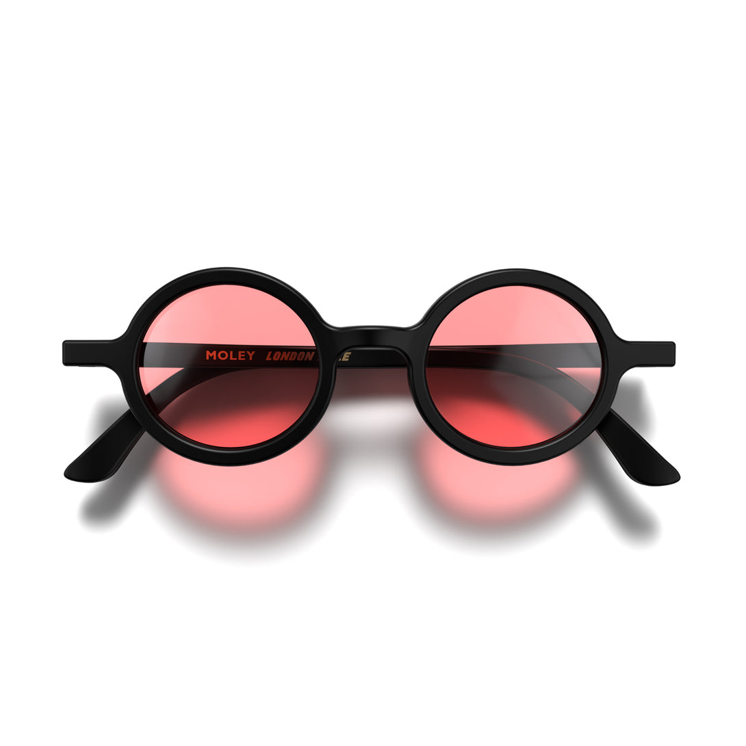 Front - Moly sunglasses matt black featuring an eccentrically round frame and red UV400 lenses. The perfect accessory.