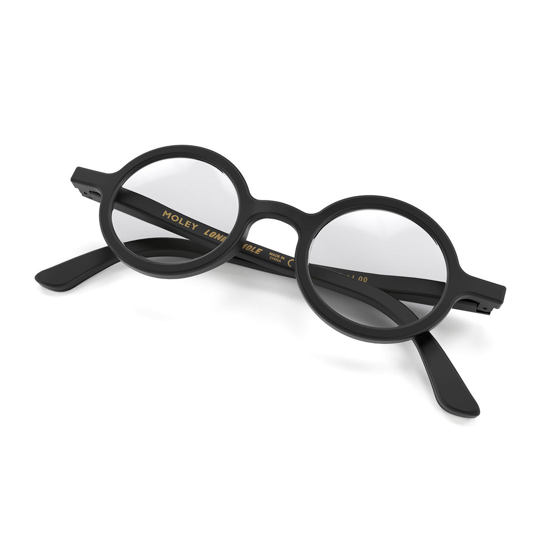 Folded skew - Moley Blue Blocker Glasses in matt black featuring an eccentrically round frame and the ability to protect your eyes from artificial blue light. Ideal for fashion accessories, screen time, office work, gaming, scrolling on a mobile, and watching TV. 