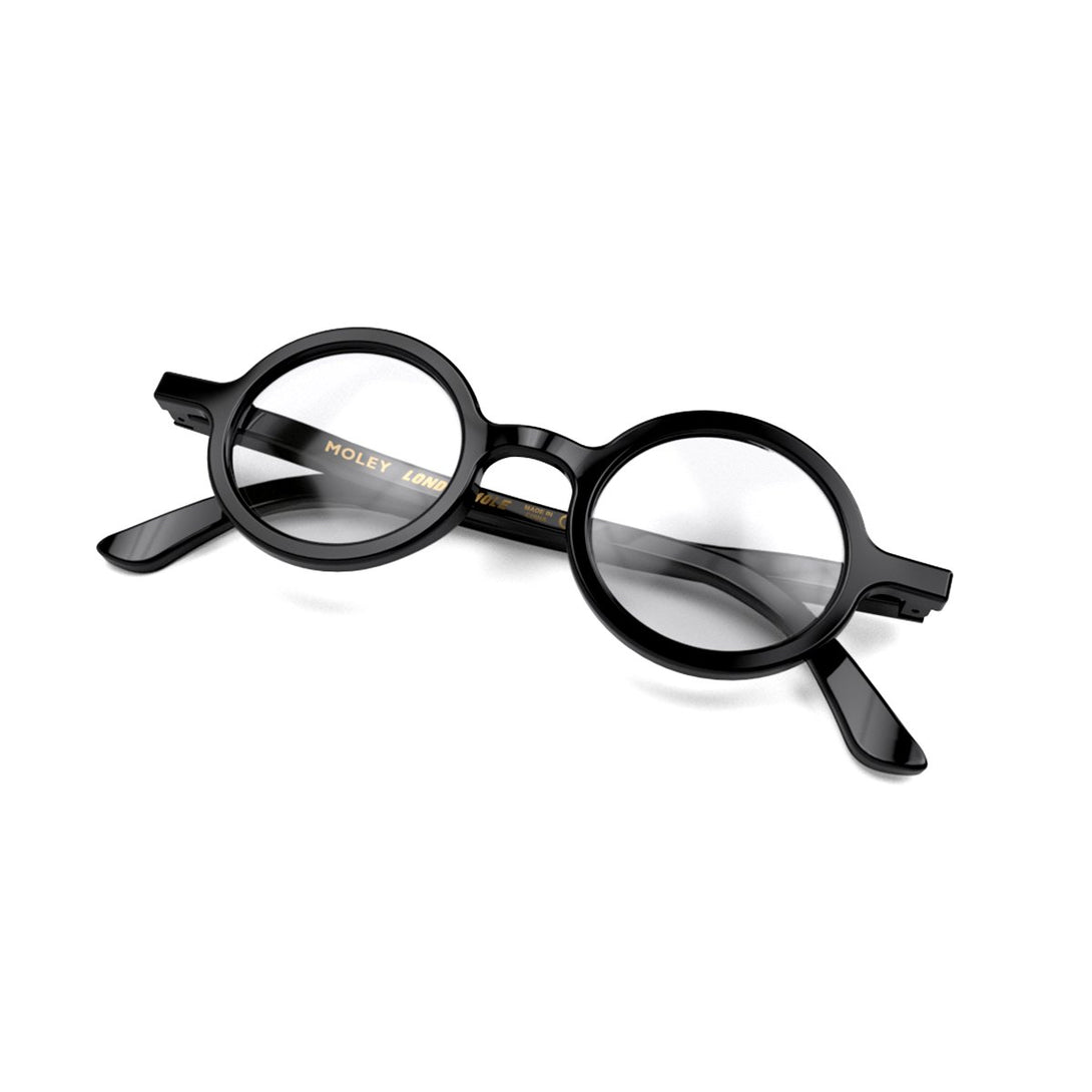 Closed skew - Moley Reading Glasses in gloss black featuring an eccentrically round frame and provide crystal clear vision. Available in a + 1, 1.5, 2, 2.5, 3 prescriptions.