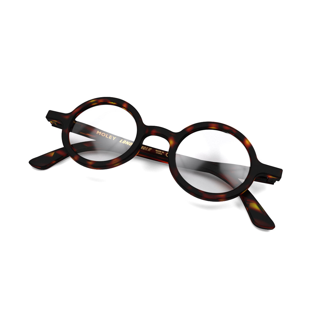 Folded skew - Moley Reading Glasses in matt tortoiseshell featuring an eccentrically round frame and provide crystal clear vision. Available in a + 1, 1.5, 2, 2.5, 3 prescriptions.