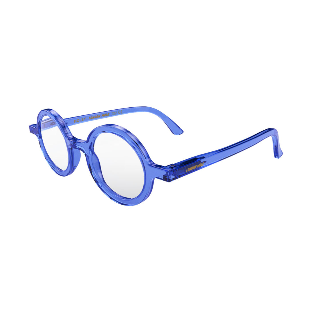 Open skew - Moley Blue Blocker Glasses in transparent blue featuring an eccentrically round frame and the ability to protect your eyes from artificial blue light. Ideal for fashion accessories, screen time, office work, gaming, scrolling on a mobile, and watching TV. 
