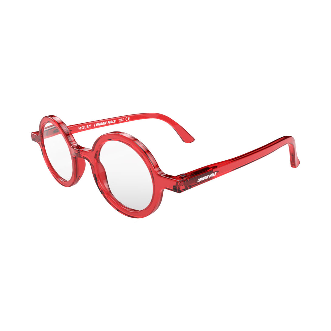 Open skew - Moley Reading Glasses in transparent red featuring an eccentrically round frame and provide crystal clear vision. Available in a + 1, 1.5, 2, 2.5, 3 prescriptions.